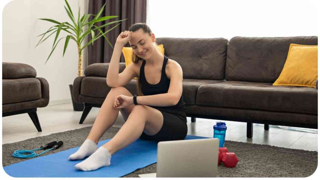 a person sitting on a yoga mat in front of a laptop